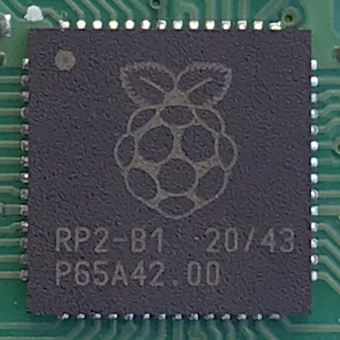 The QFN-56 RP2040 in dirty-bench condition — used illustratively here for the RP2350 family, which uses the same package style. The RP2350B is a larger QFN-80 variant of the same chip family.