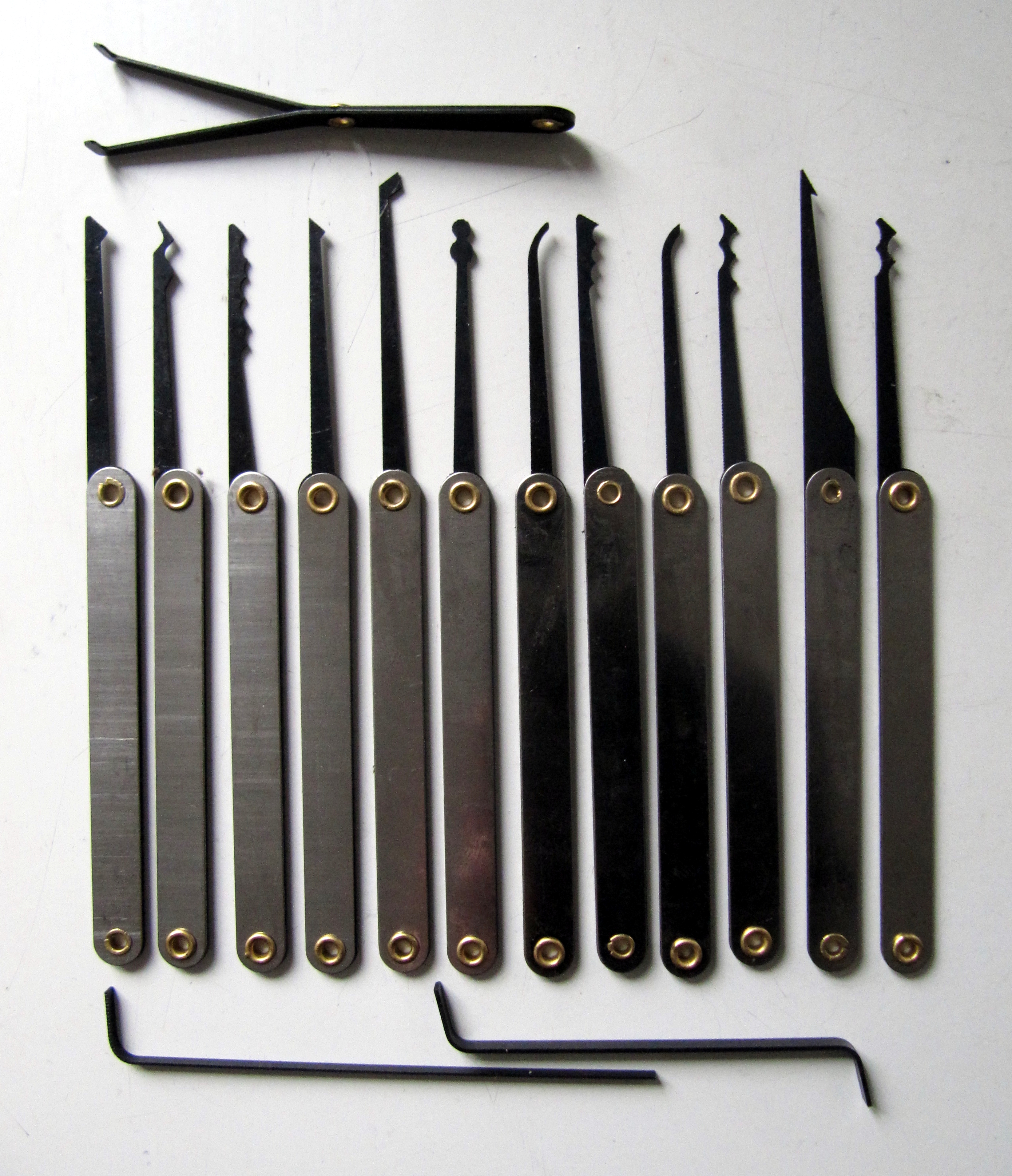 A lock-picking set in working configuration — tension wrenches, single-pin picks, rake picks, and the broader physical-bypass toolkit that supports the red-team's physical-entry layer. Modern red-t…