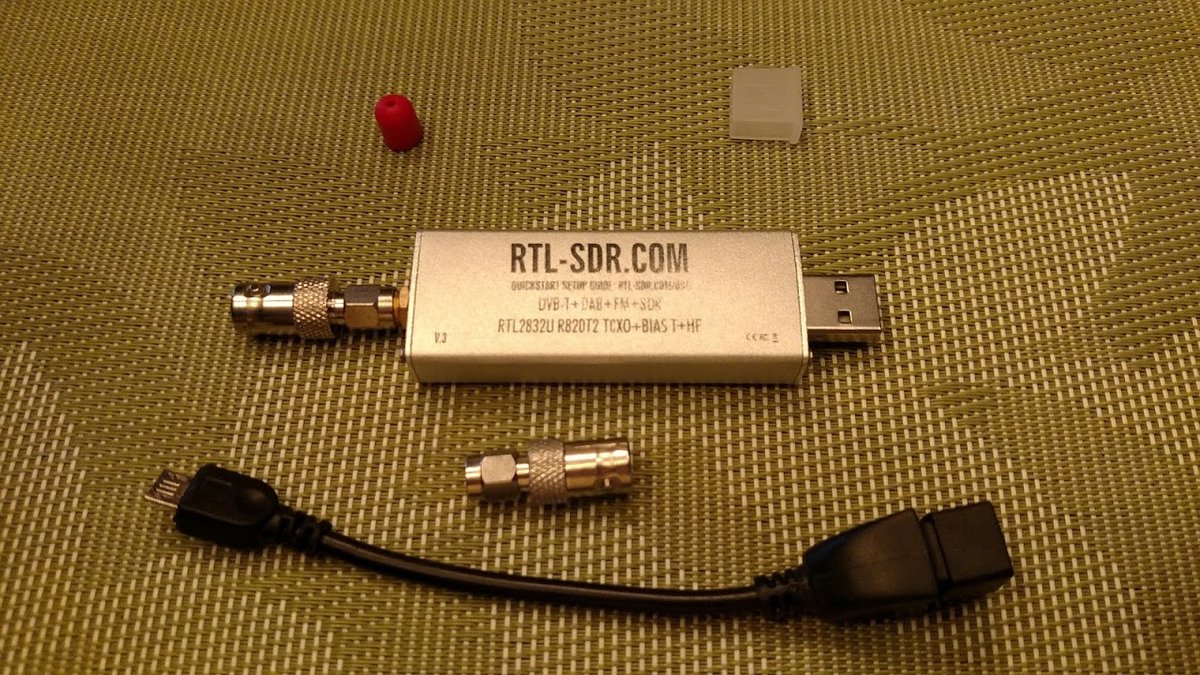 An RTL-SDR Blog V3 dongle on the bench. Reused from Vol 9 §3.3 as the canonical entry-tier SDR. The V3 is — as of mid-May 2026 — the in-production current model. The V4 (R828D tuner, 1 PPM TCXO, bu…
