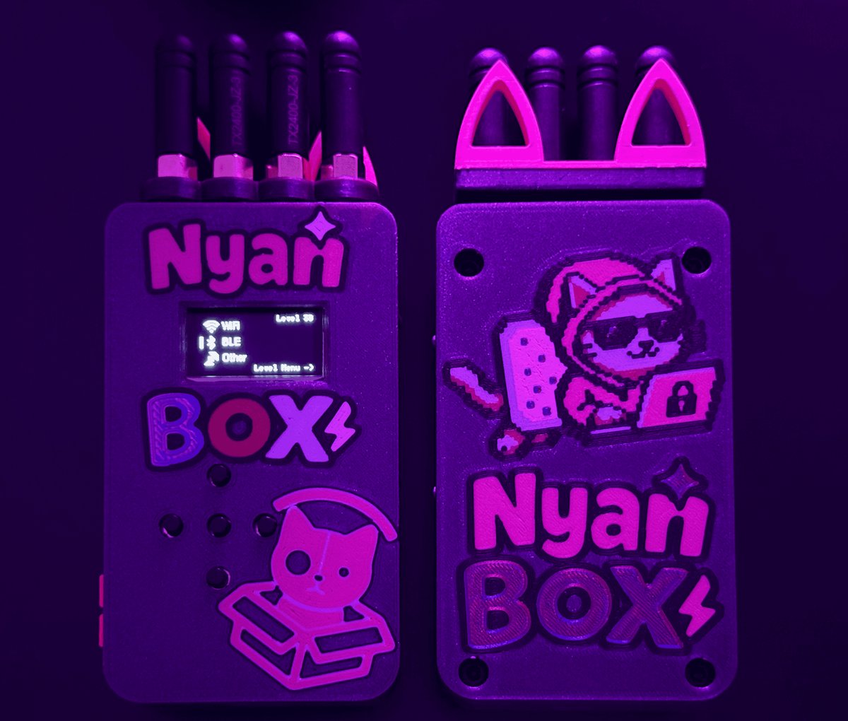The assembled nyanBOX — the printed enclosure, the 0.96" OLED, the four 2.4 GHz antennas (one each for the ESP32 + 3× NRF24), and the arrow-key UI. This is the education-first multi-radio handheld …